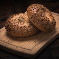 two round bagels with poppy seeds on a cutting board