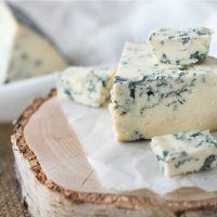 Tasty blue cheese on a wooden background