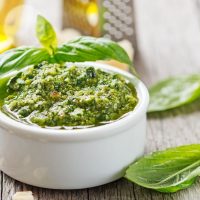 pesto sauce in a white bowl on top of the table