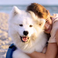 girl hugging her samoyed pet