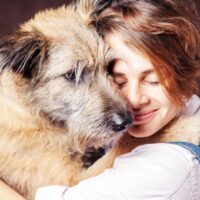 woman hugging a shaggy dog