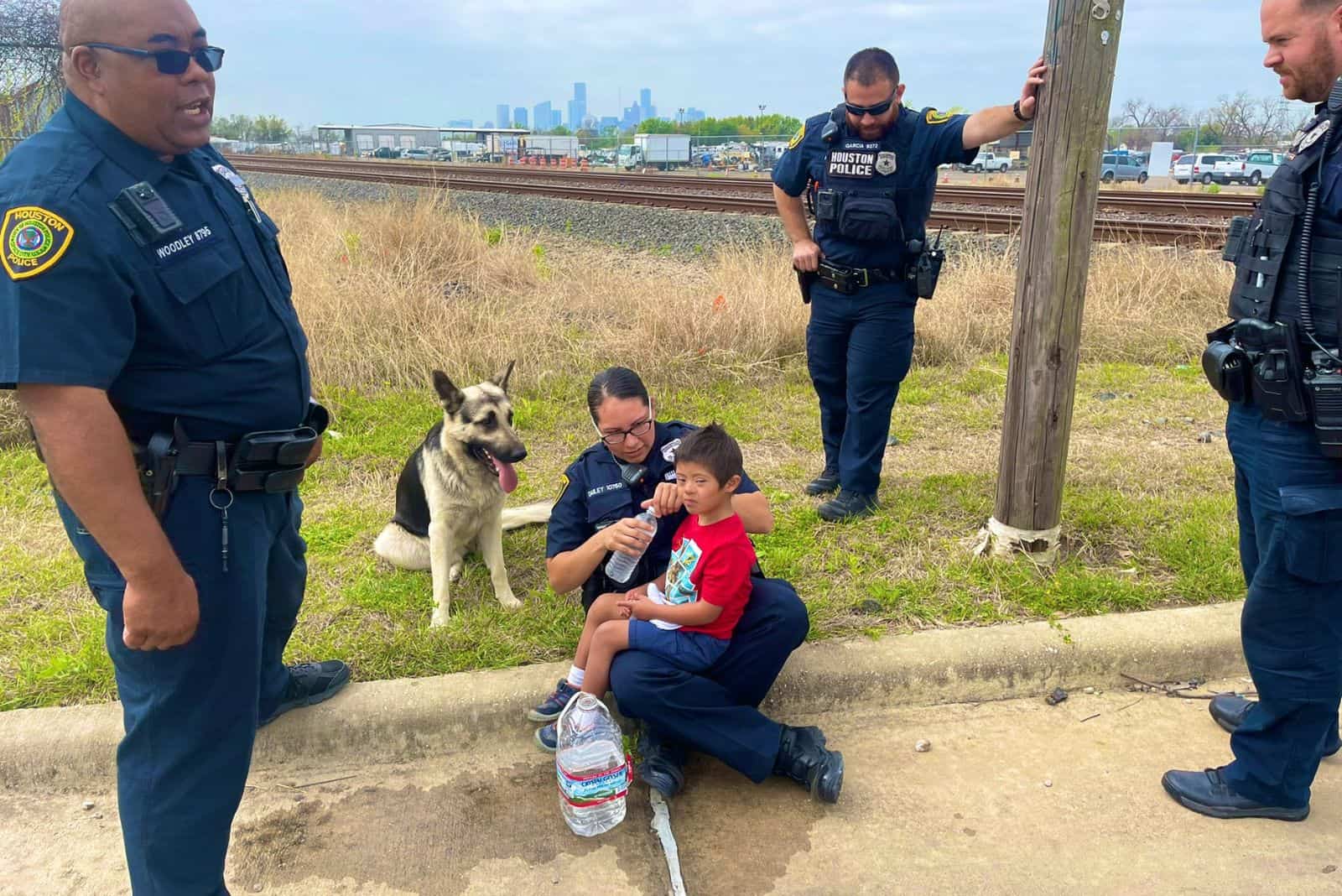 police officers with little boy and a dog