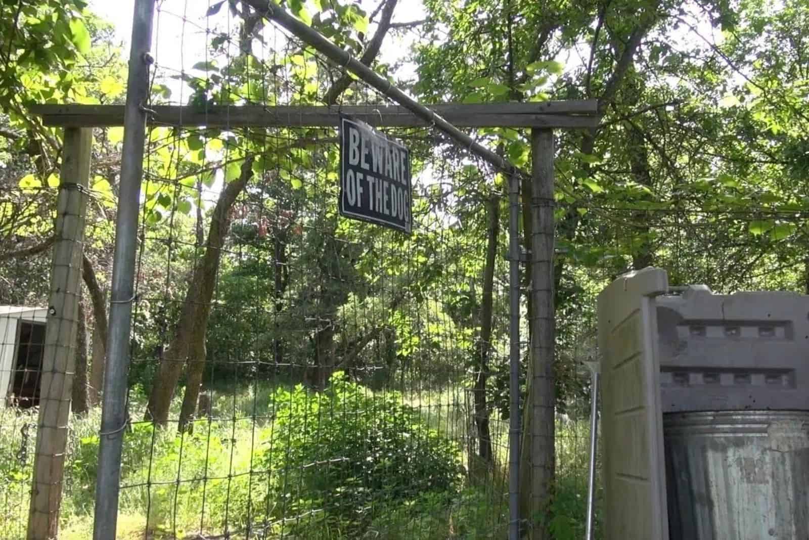 beware of the dog sign on fence