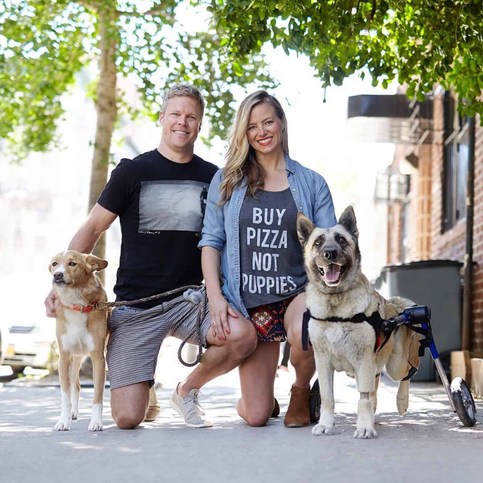 happy couple with two dogs on the street