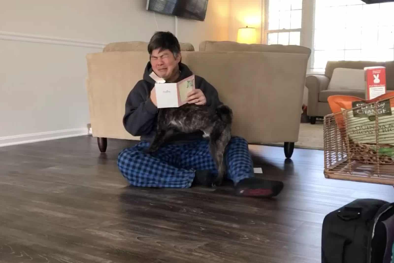 crying man sitting on the floor with his dog