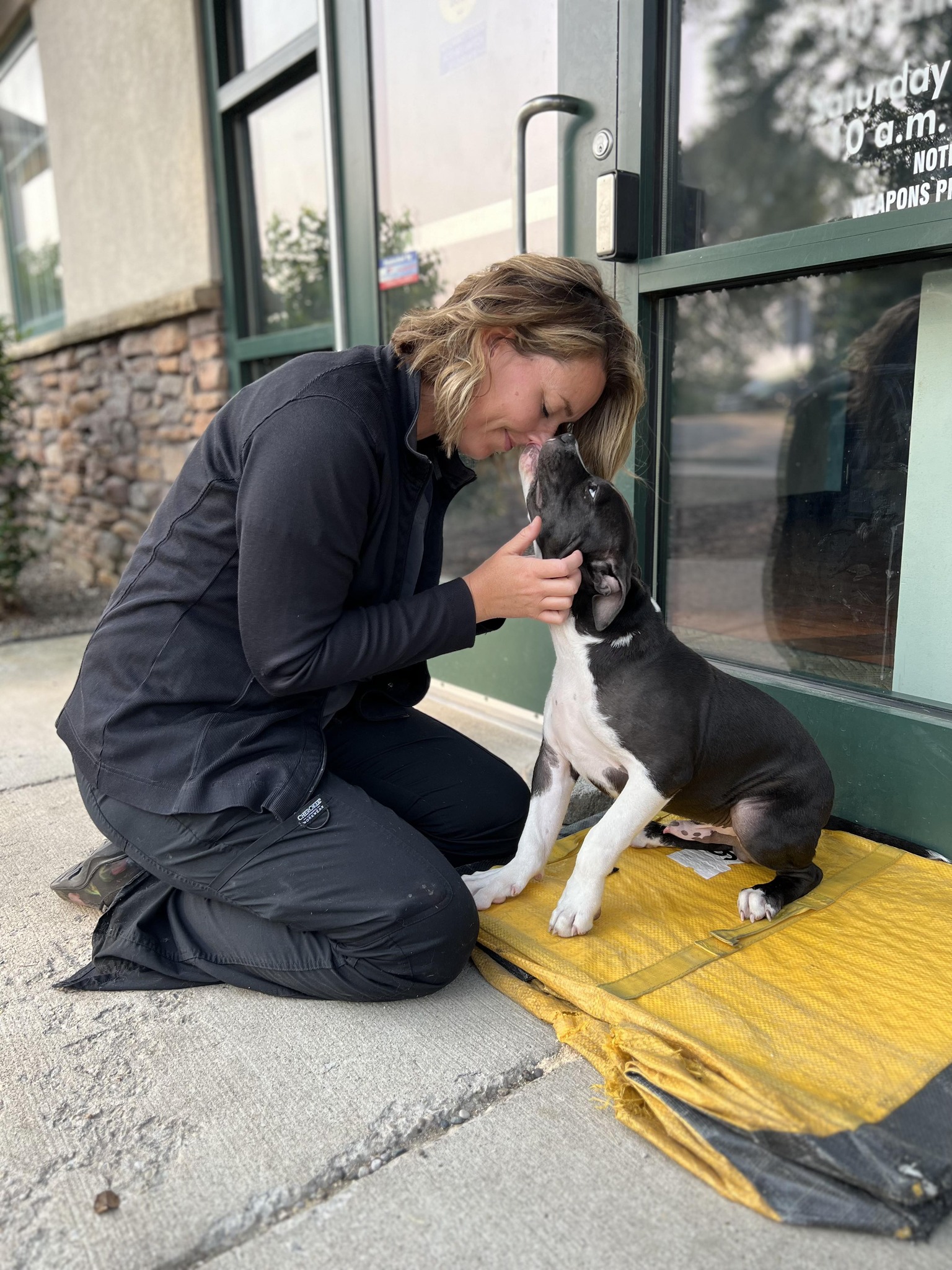 woman and the dog sitting on the side walk