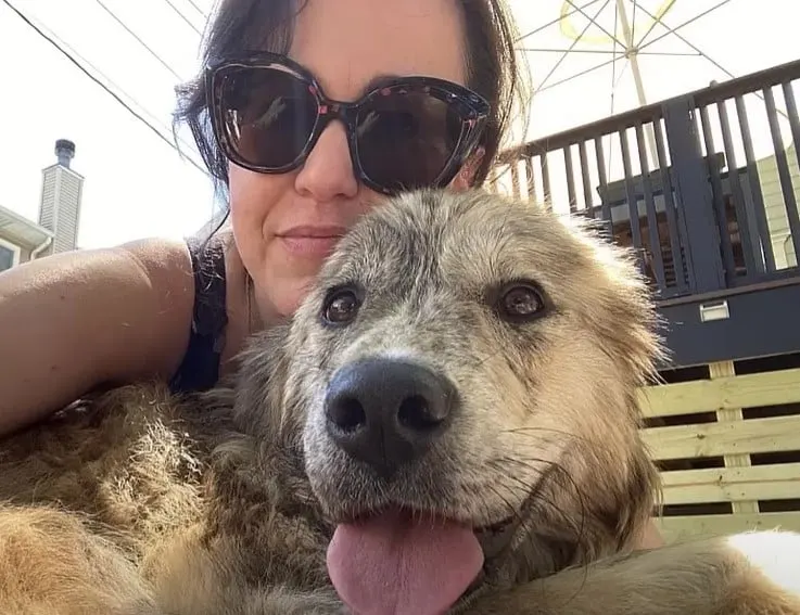 adopted dog takes a picture with a woman