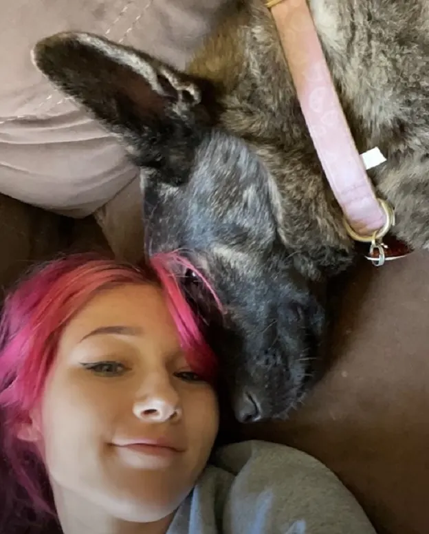 the dog lies next to the girl's head