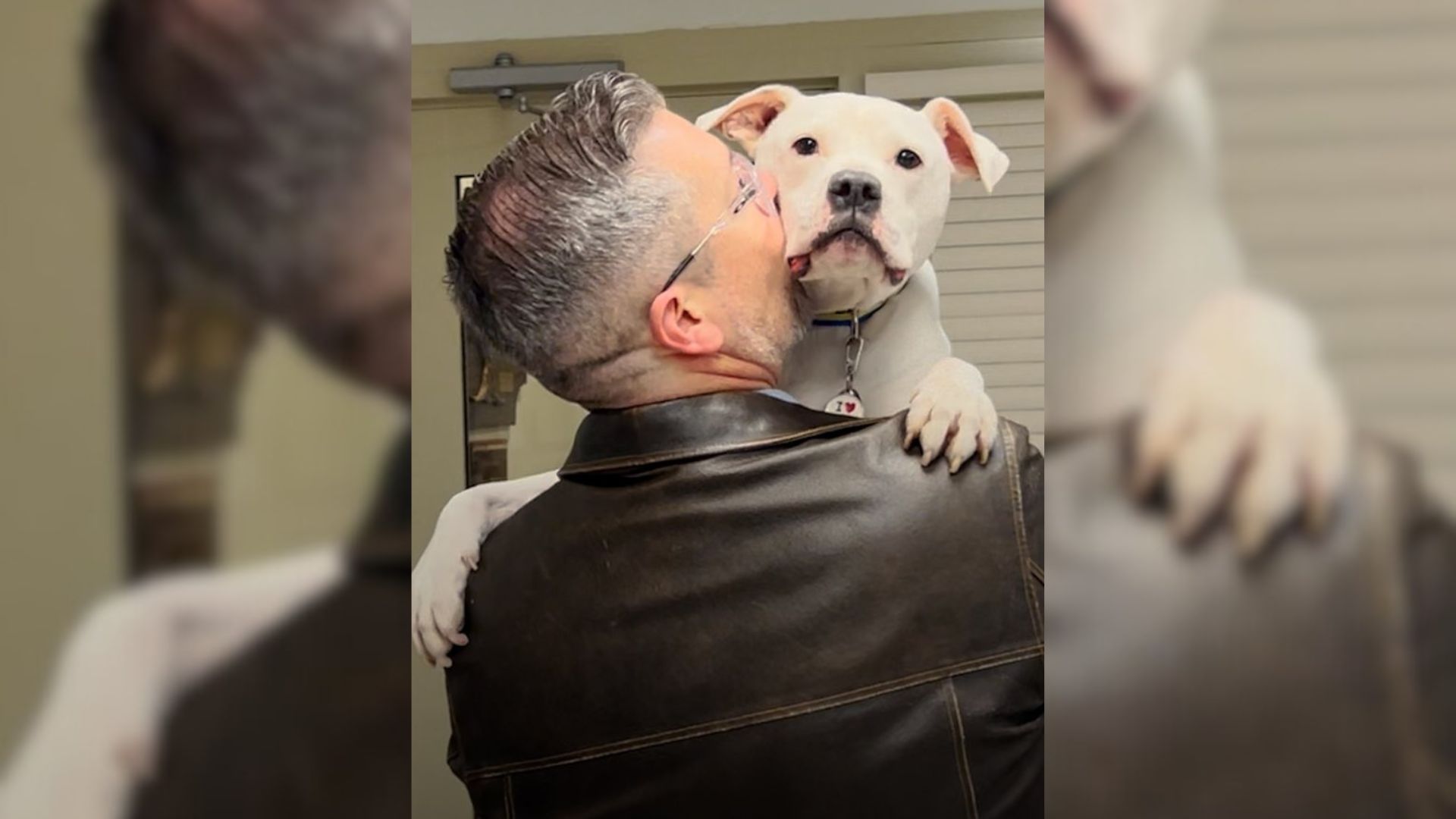 Guy holding his white dog