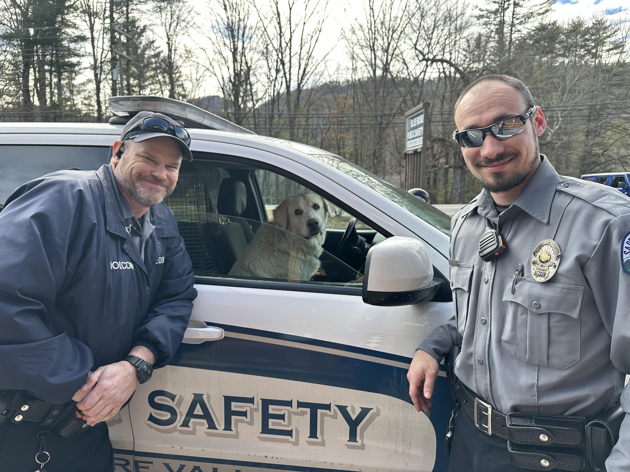 police officers posing with dog in the car