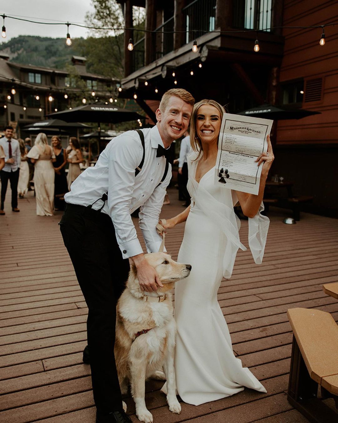 couple with a dog holding their marriage license