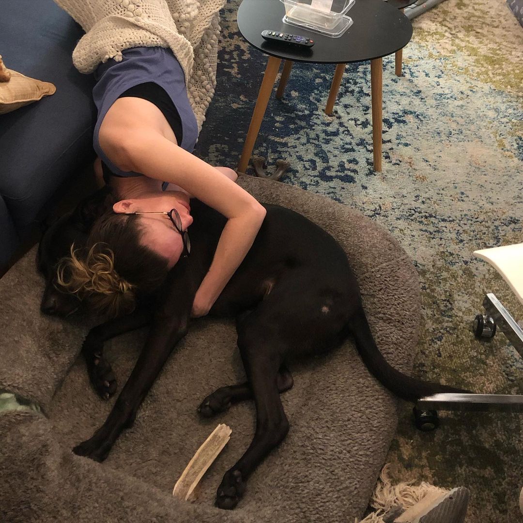 woman laying on the dog