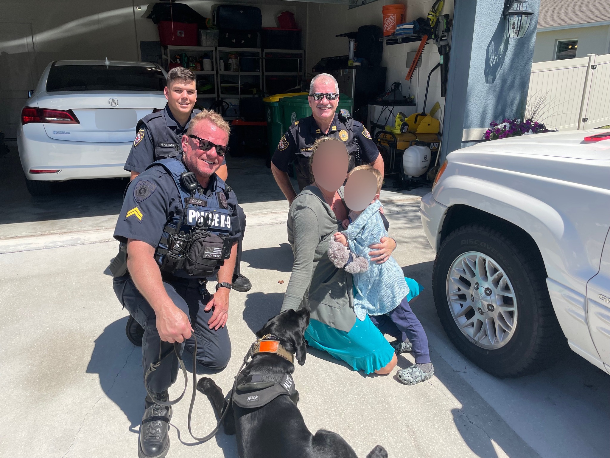 police officers with dog posing with woman and her son