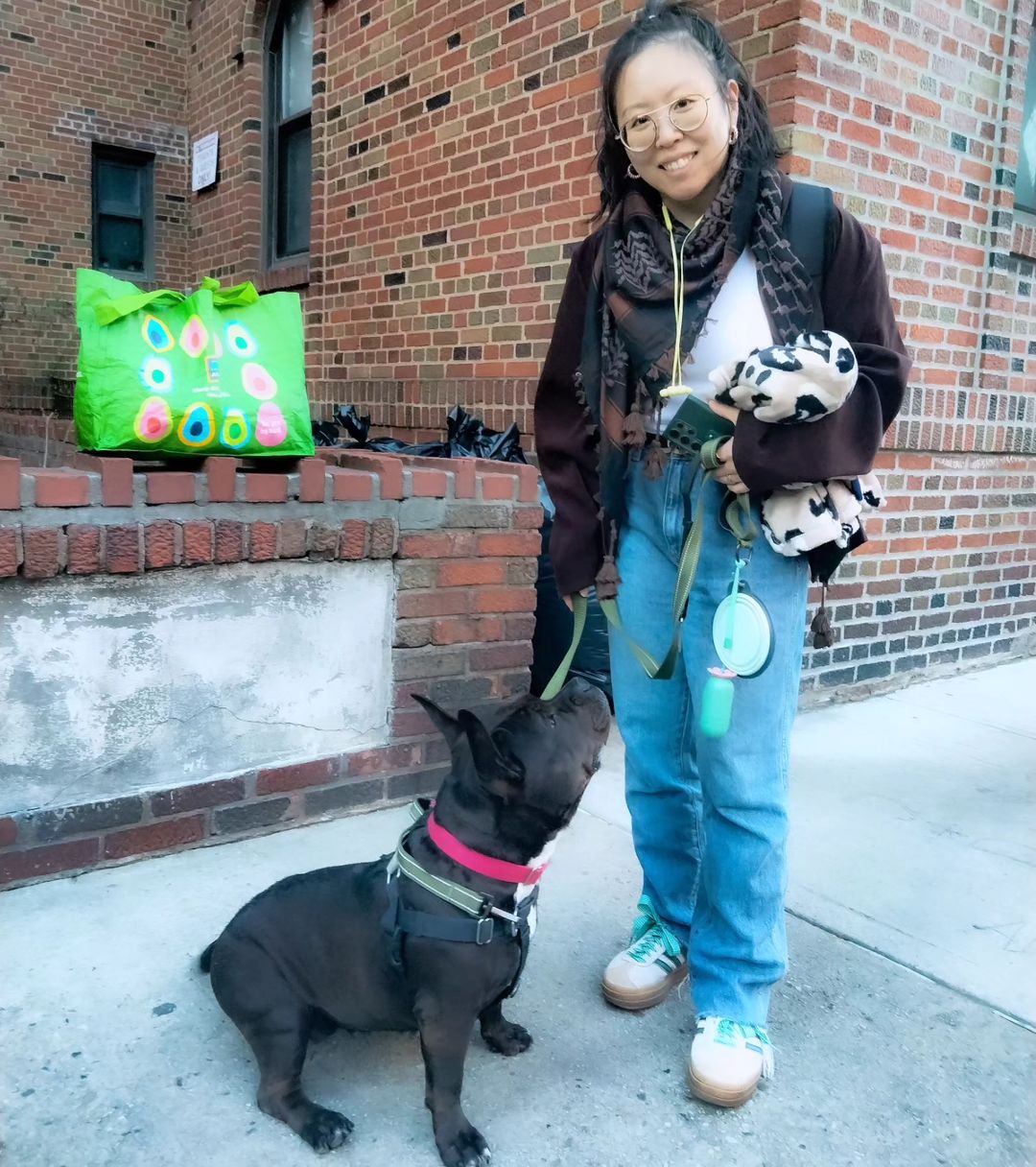 smiling woman posing with dog on street