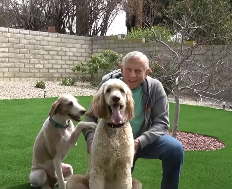 senior man posing with dogs