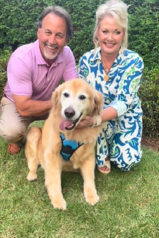 man and woman with golden retriever