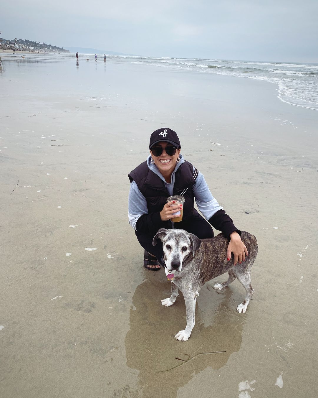 smiling woman with dog on the beach