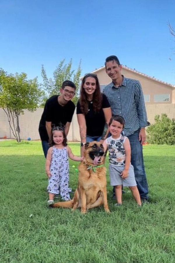 smiling family with a dog in the garden