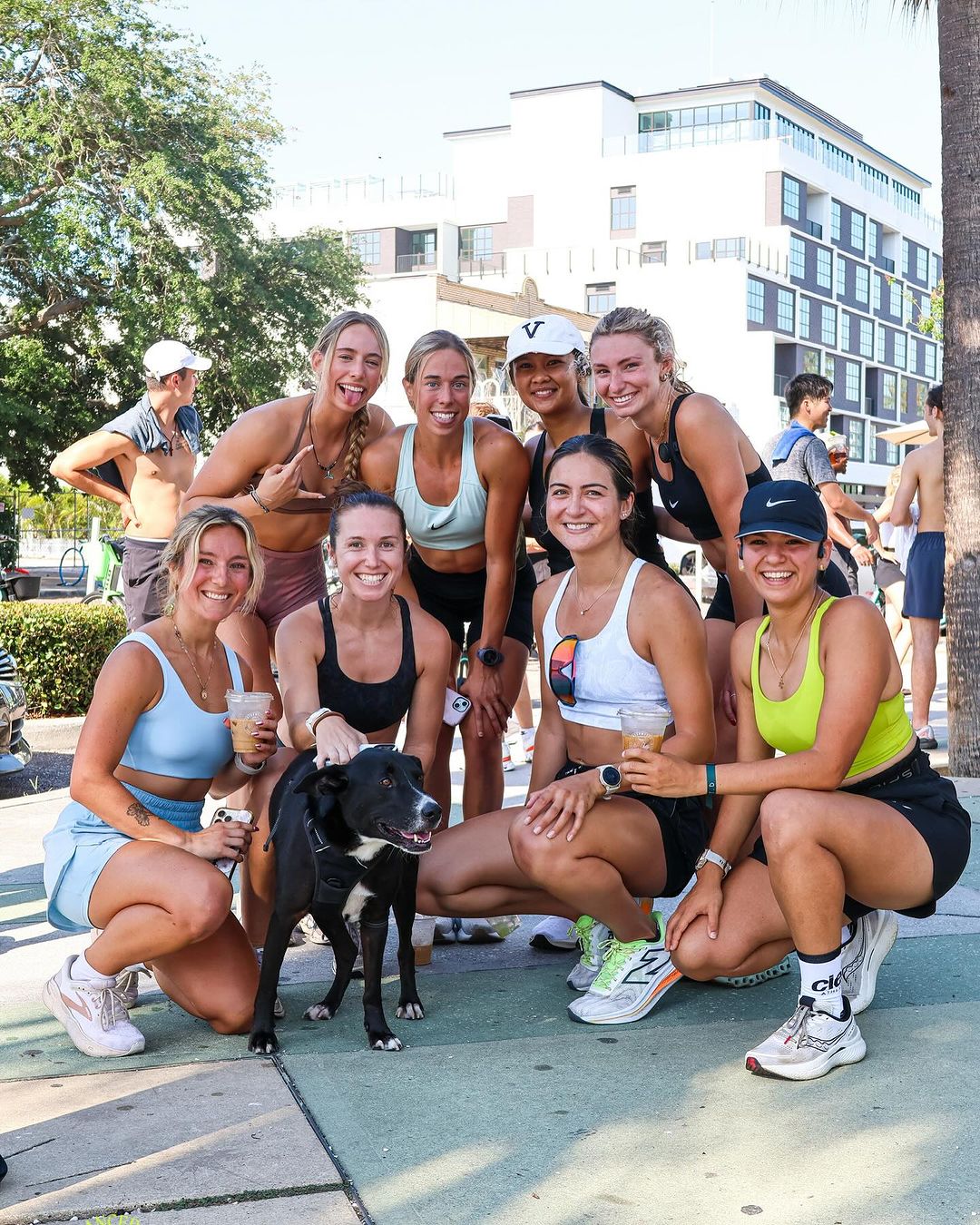 smiling women posing with dog on the street