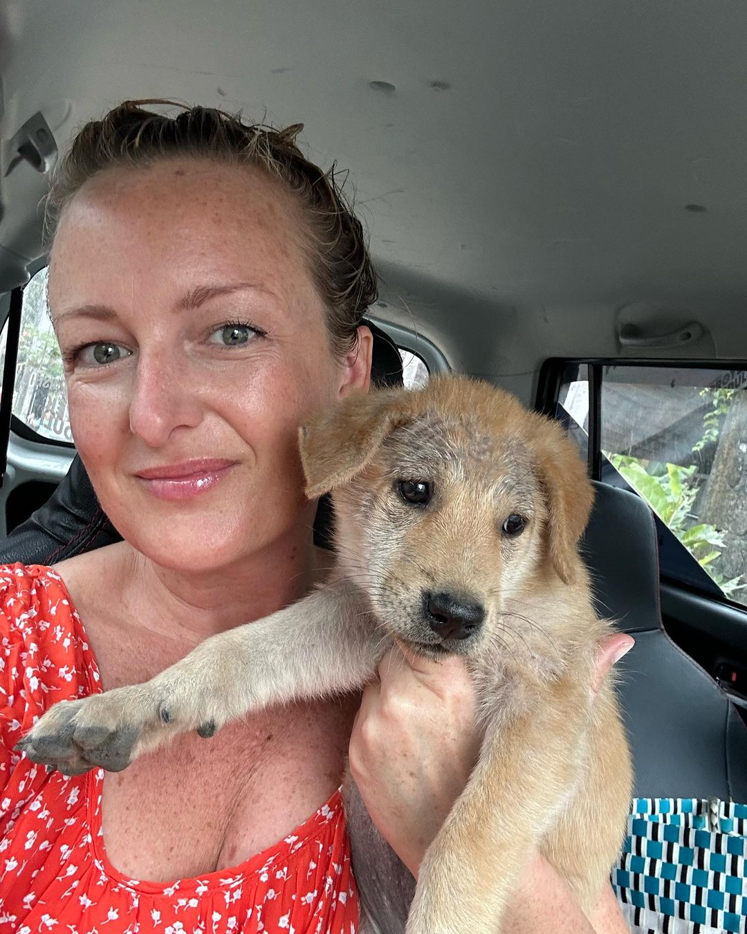 woman and puppy in car