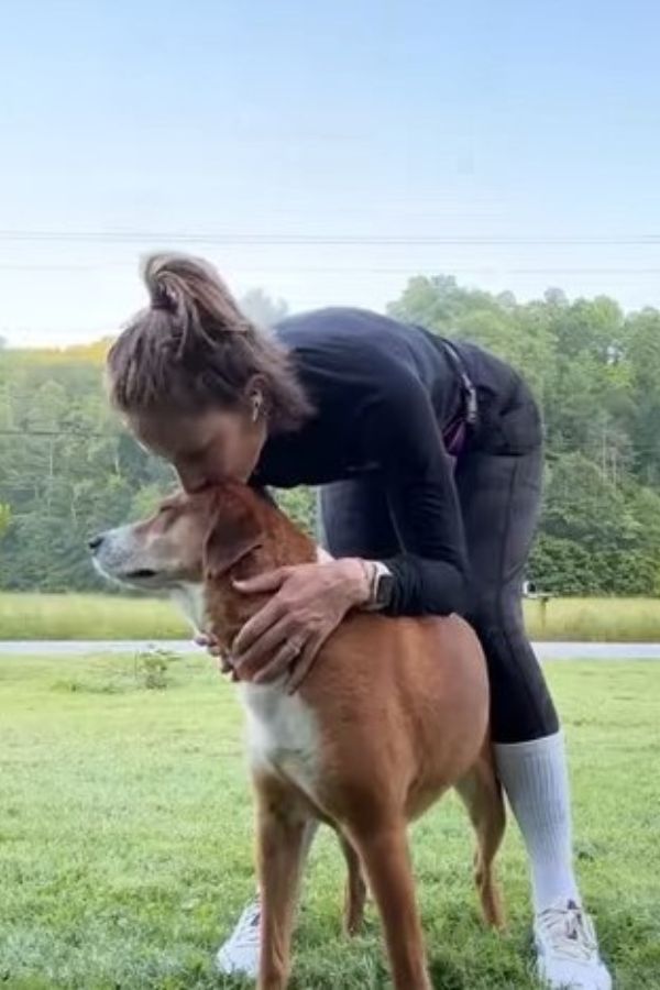 woman kissing a dog