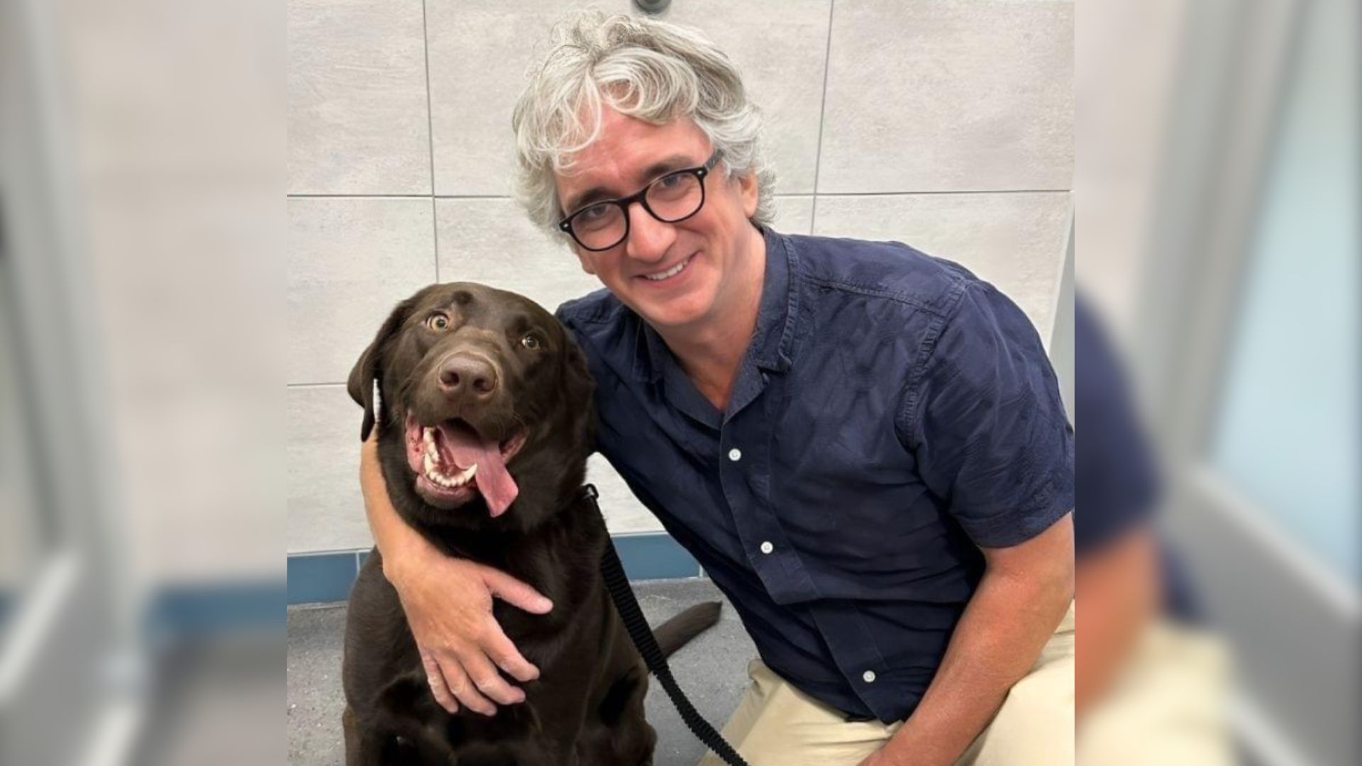 a dog from the shelter takes a picture with its owner