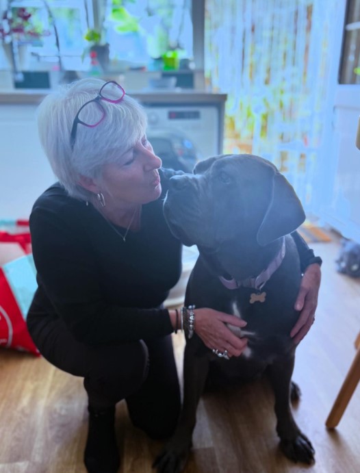 a woman poses with a dog, they take pictures