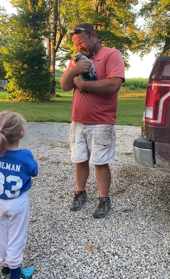 crying man holding a puppy