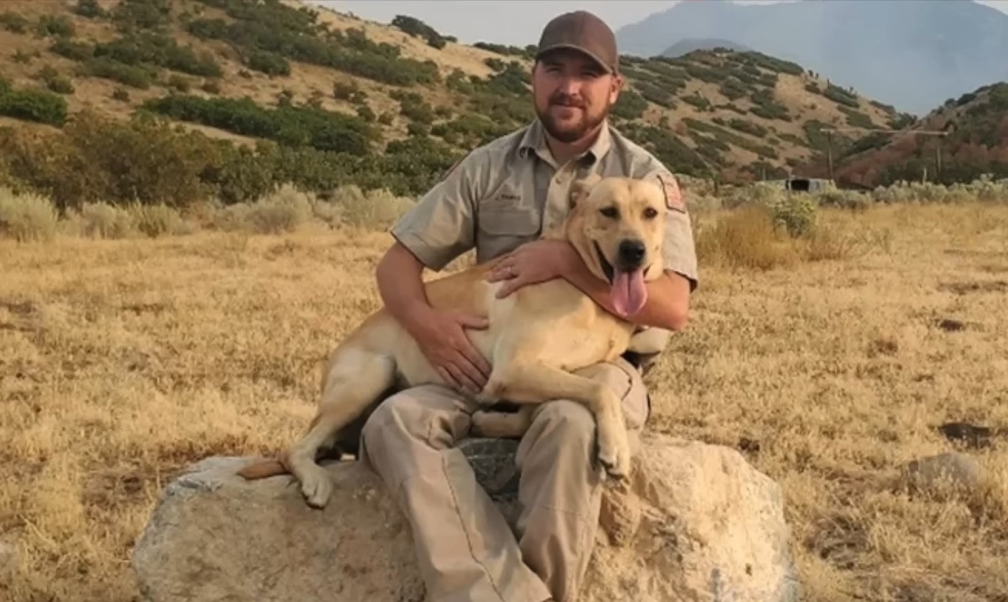 man and dog sitting in nature