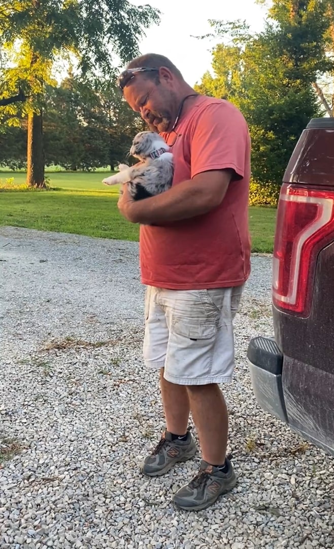 man holding tiny puppy