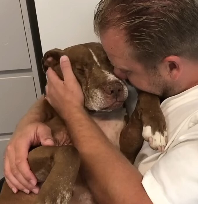 man hugging the dog