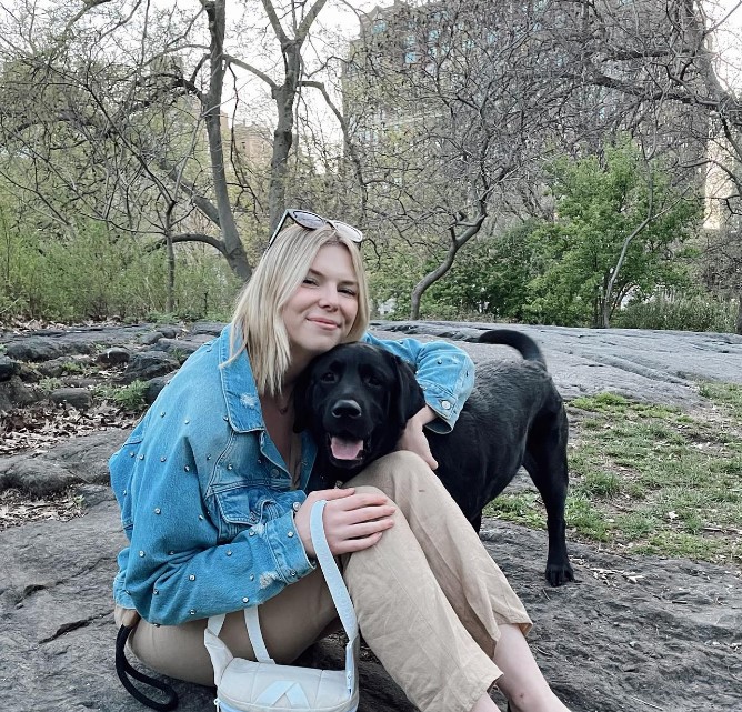 the girl takes a picture hugging her dog