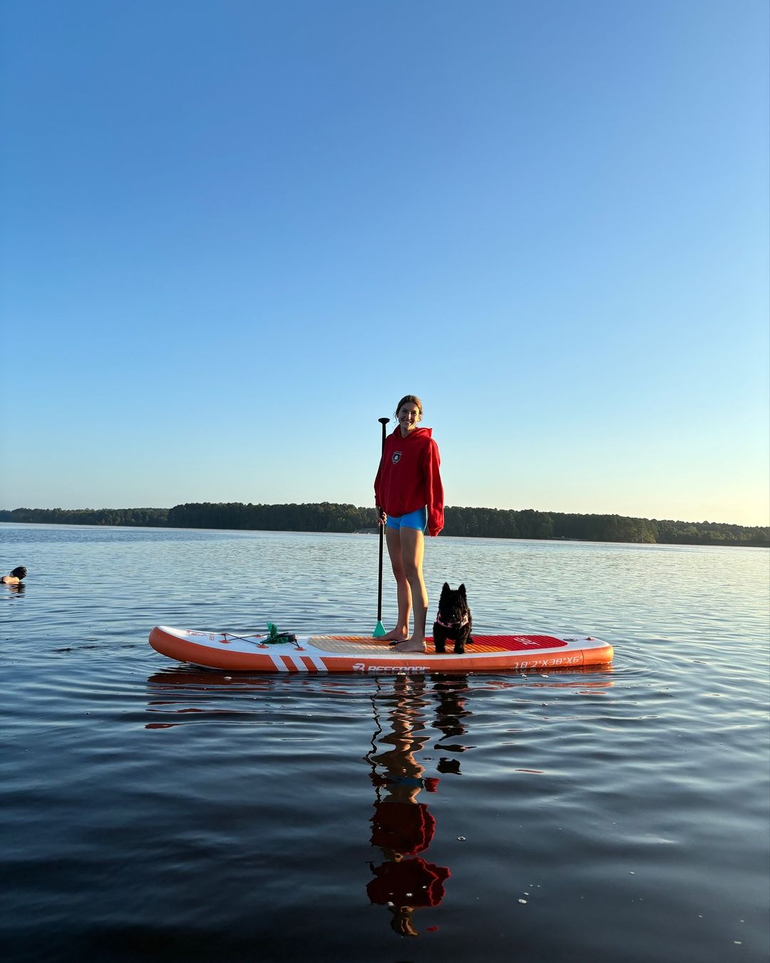 woman and dog on surfboard