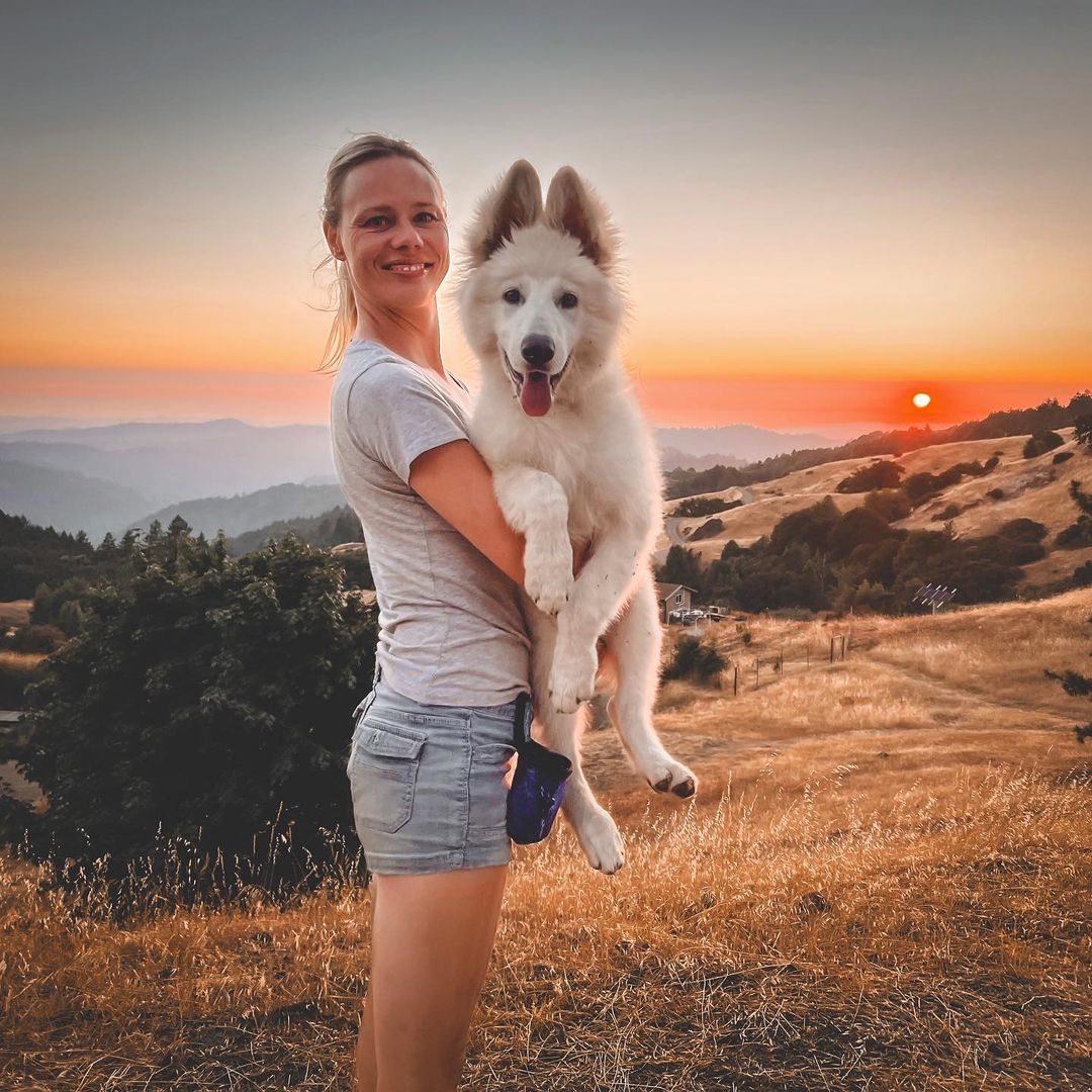 woman holding a big white dog