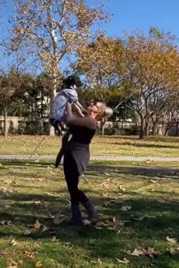 woman holding the dog at the park