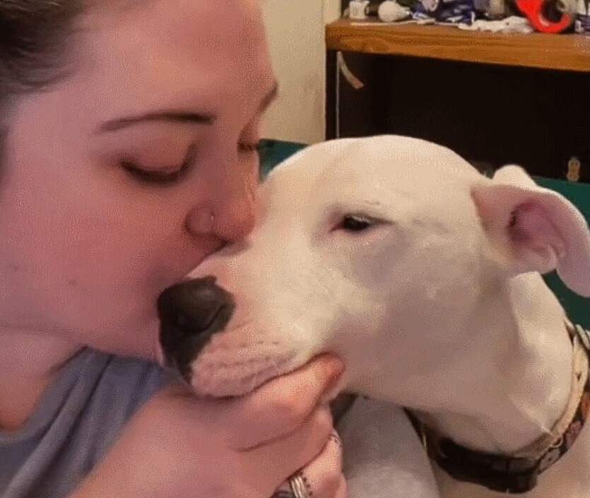 woman kissing the deaf pup