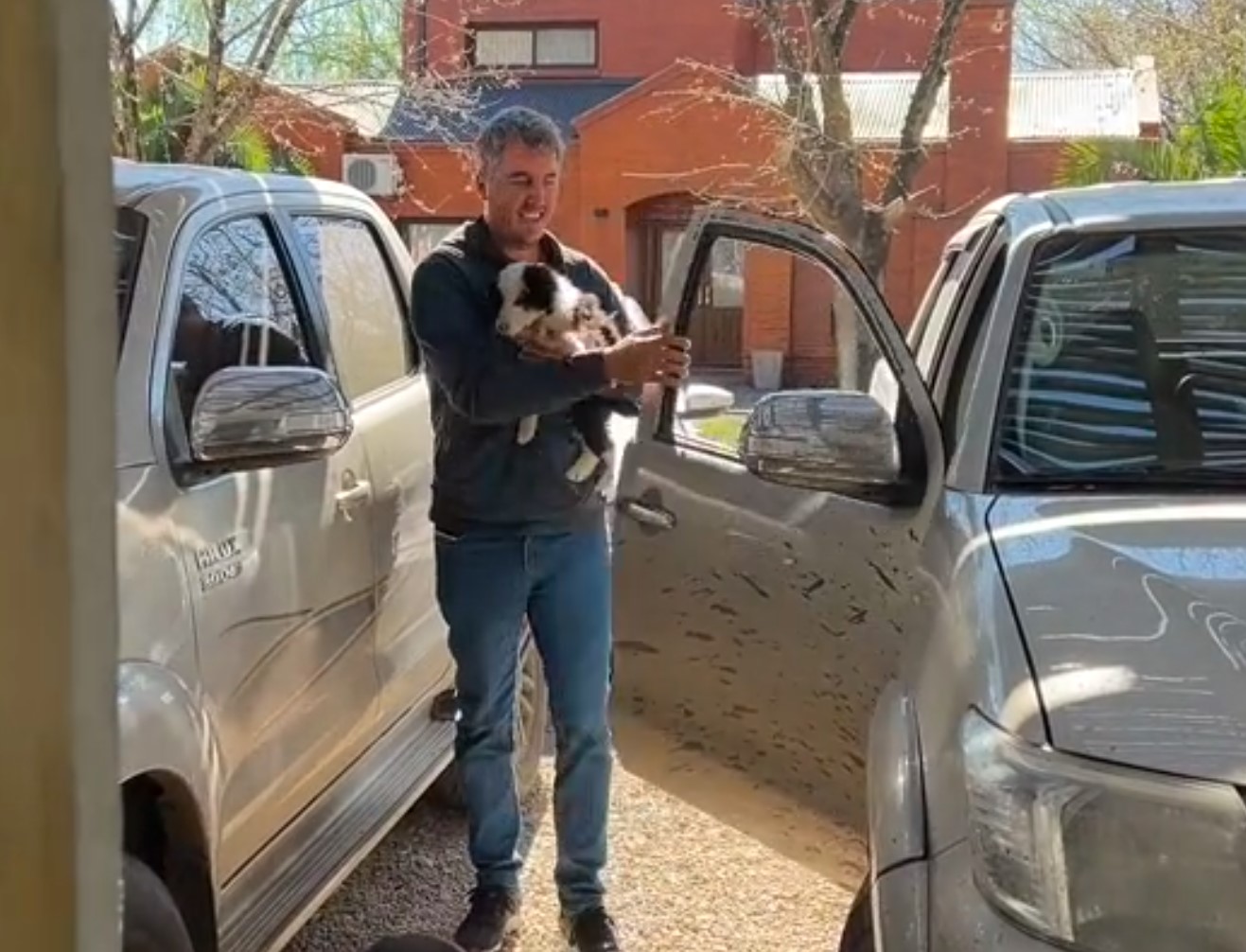 a man carries a puppy in his arms