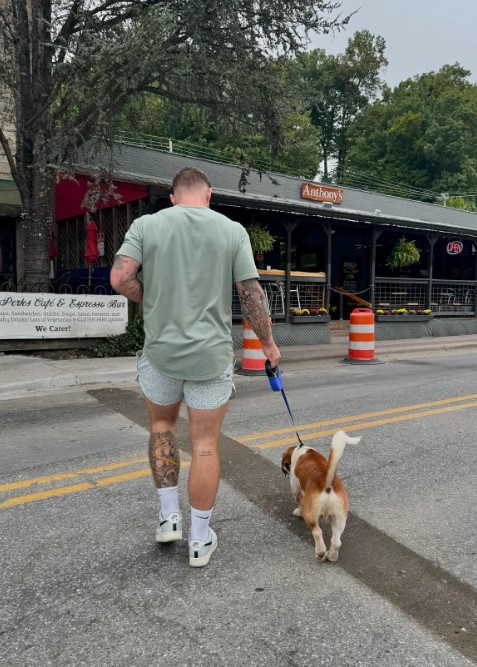 a man leads a dog on a leash