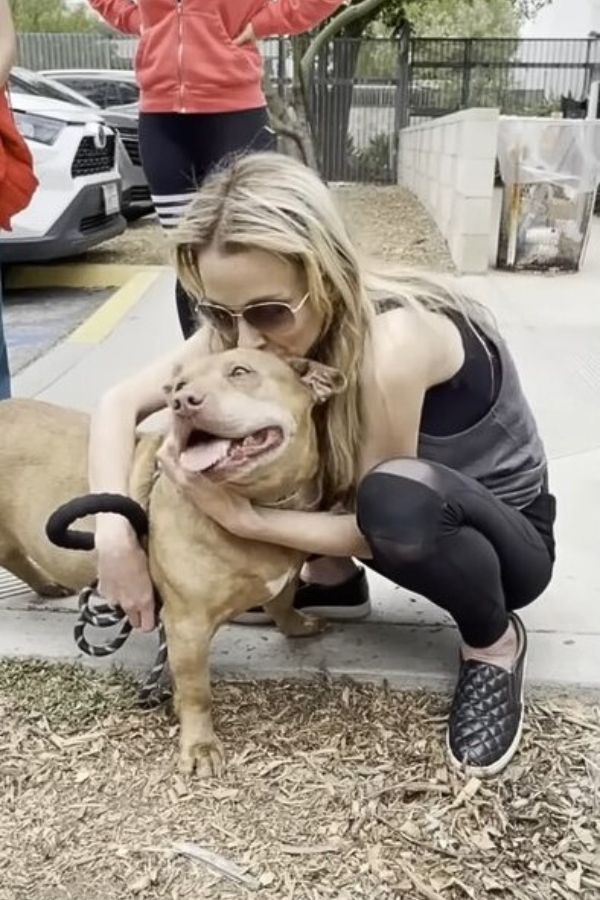 blonde woman kissing a dog