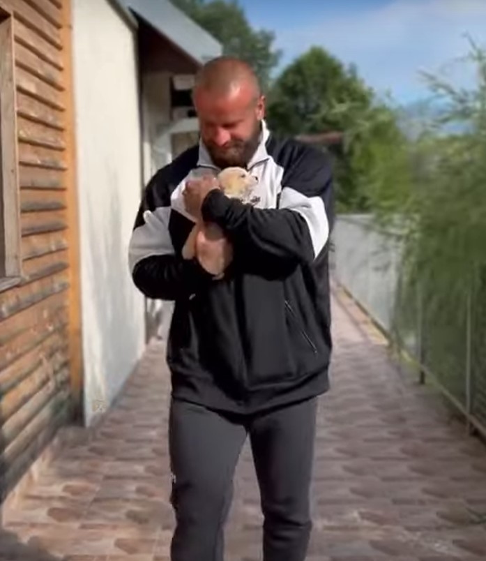 man holding a white puppy