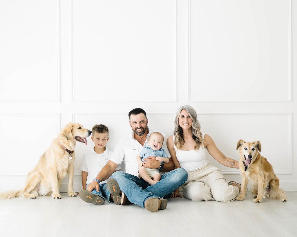 smiling family taking pictures with dogs