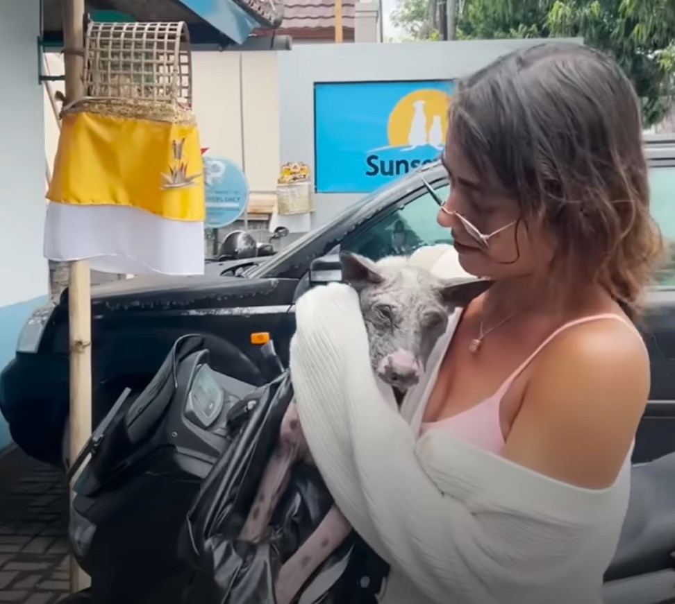 woman holding a neglected dog