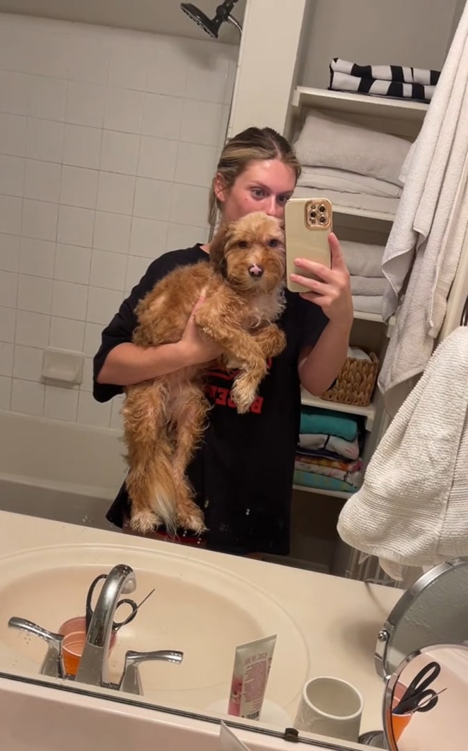 woman holding dog in bathroom