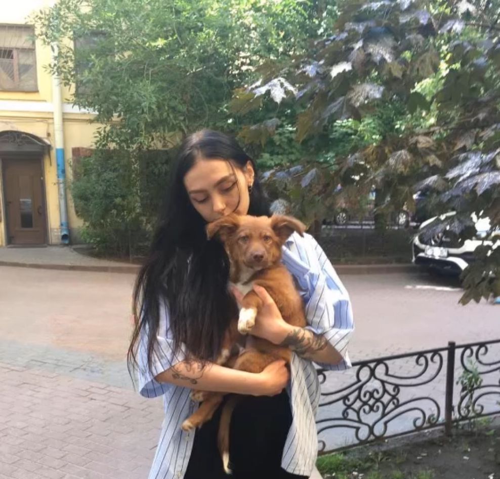 woman posing with dog in hands