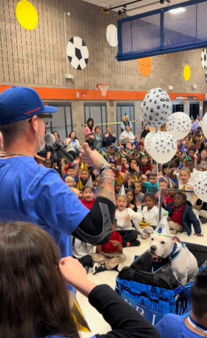 man with dog on a stage in school