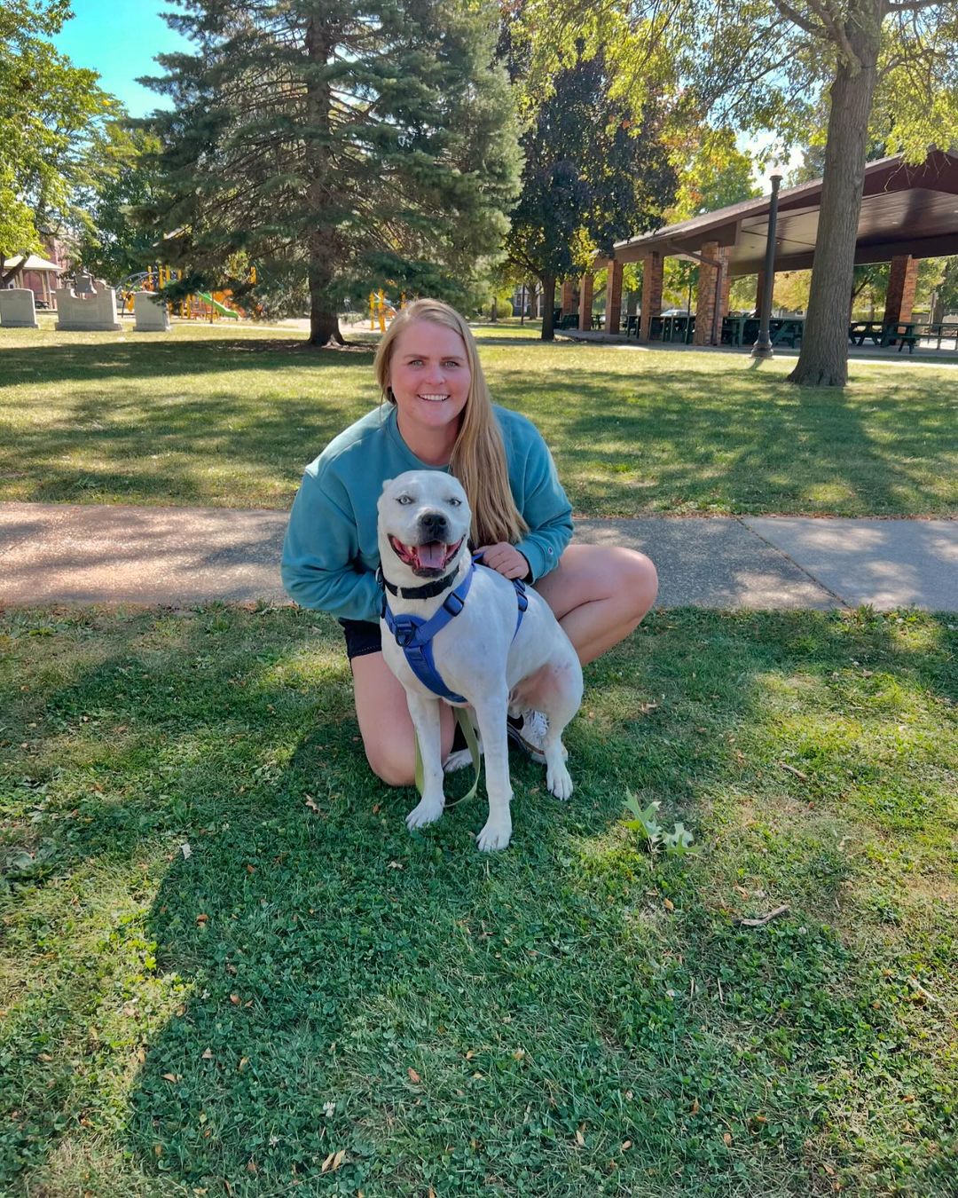 smiling woman posing with dog outdoor in the park