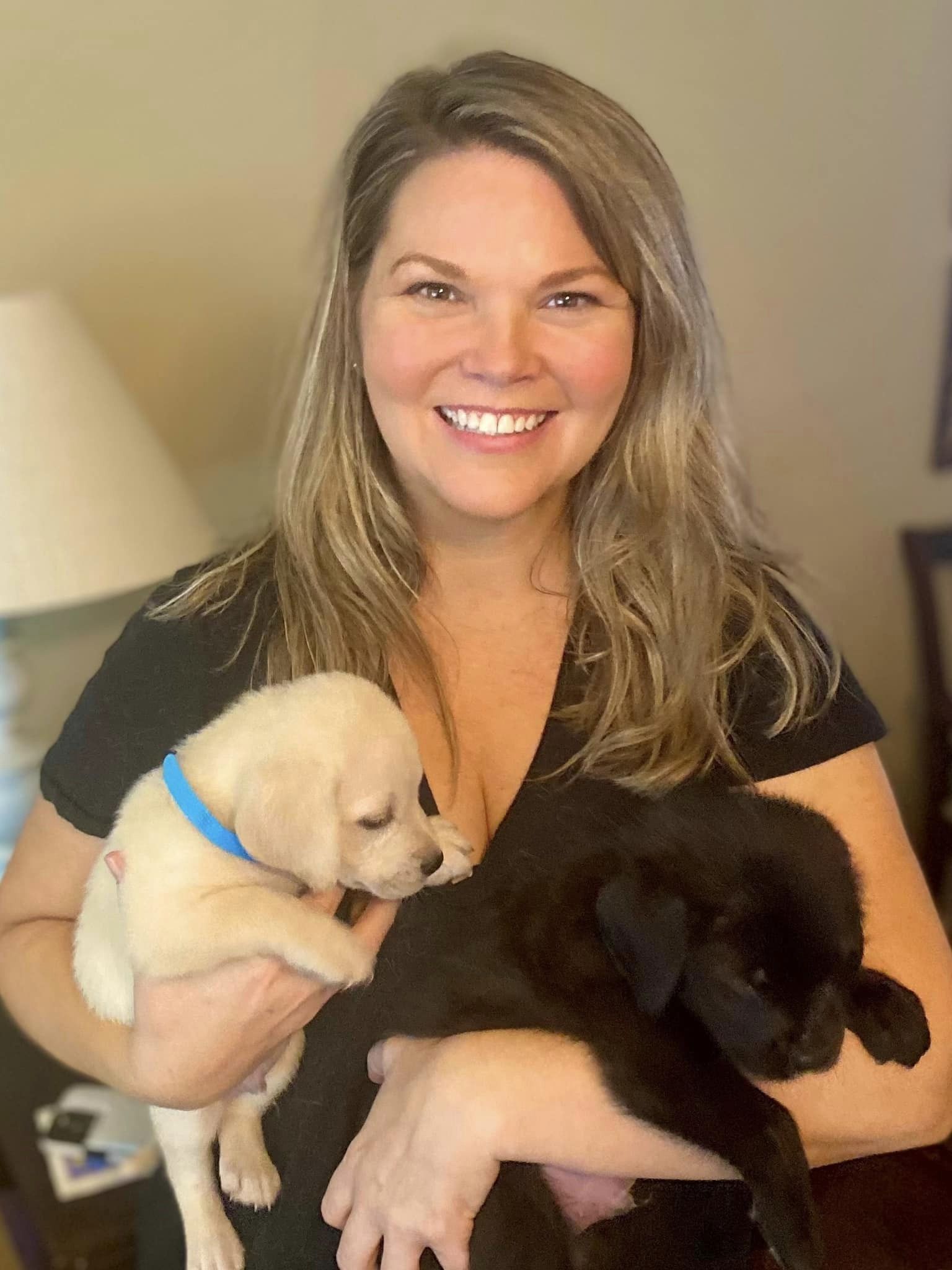 woman holding two puppies