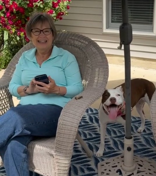 woman sitting next to a pitbull