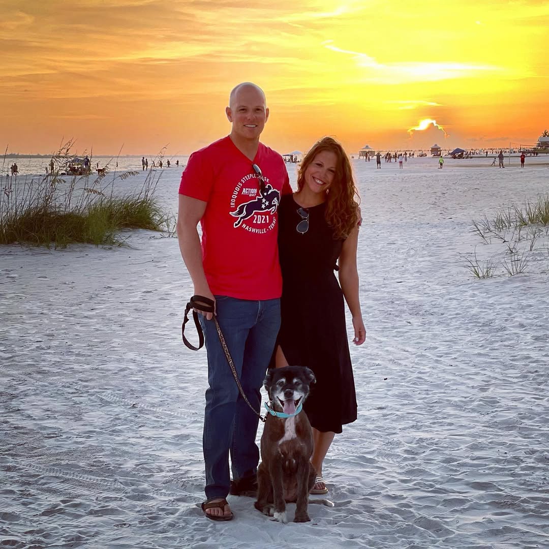 couple posing with dog on the beach