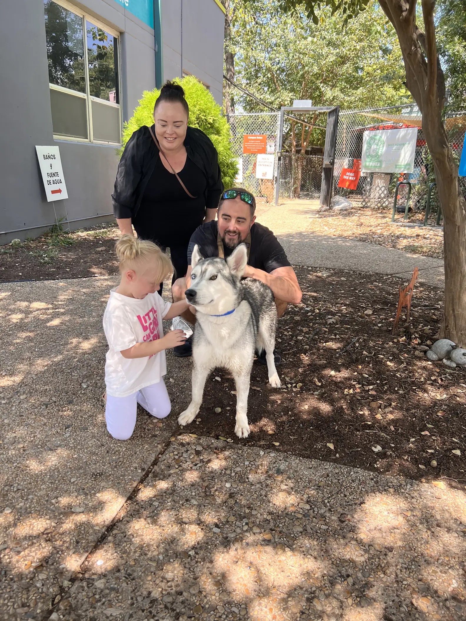 family standing with husky dog outdoor